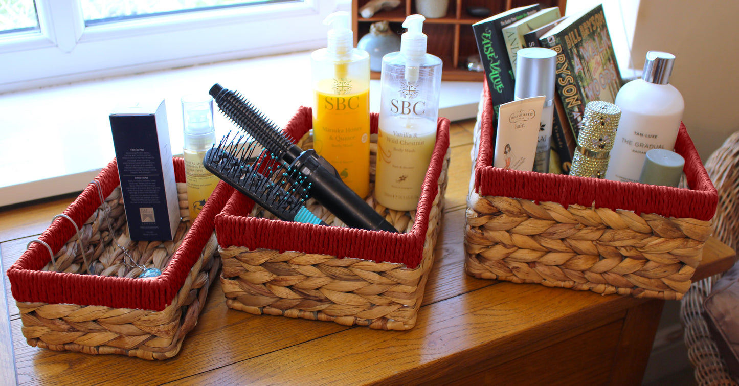Small water hyacinth rectangular baskets with red edges.