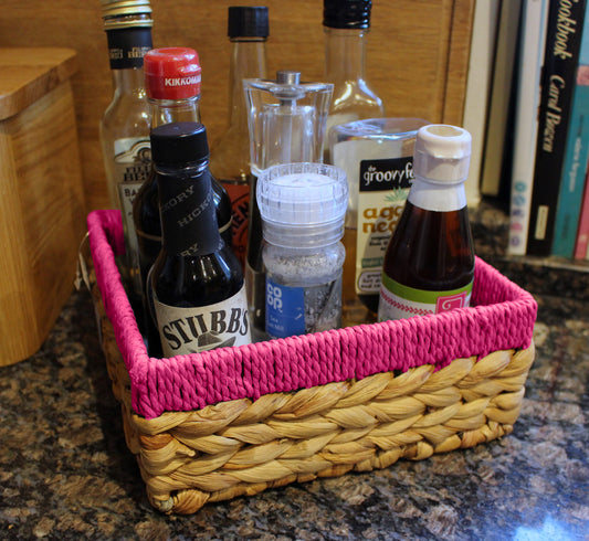 Small water hyacinth square baskets with pink edges.